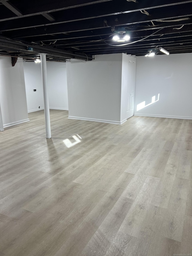 basement with light hardwood / wood-style flooring