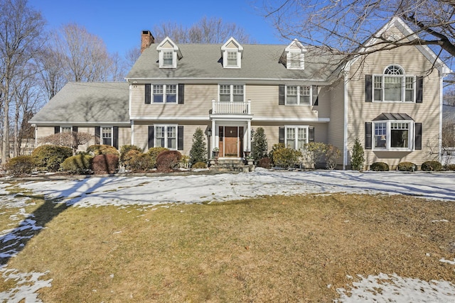 shingle-style home featuring a yard and a chimney