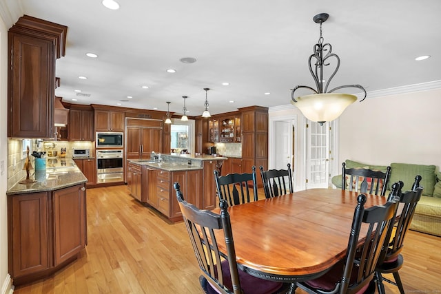 dining area featuring light wood-type flooring, ornamental molding, and recessed lighting