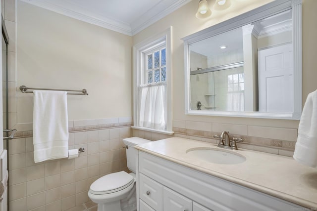 bathroom with toilet, vanity, tile walls, ornamental molding, and a shower with door