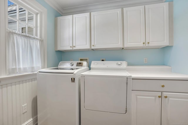 washroom with ornamental molding, cabinet space, and separate washer and dryer