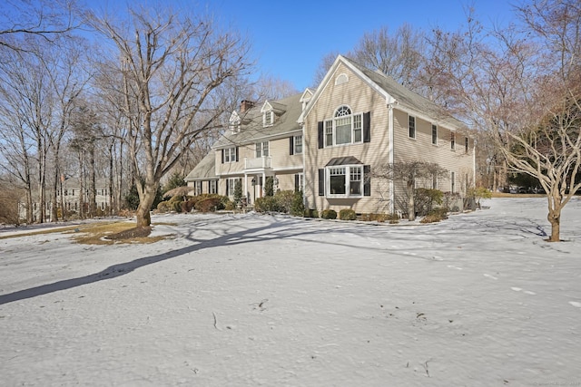 shingle-style home featuring a chimney