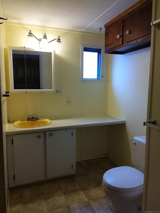 bathroom featuring vanity, a textured ceiling, and toilet