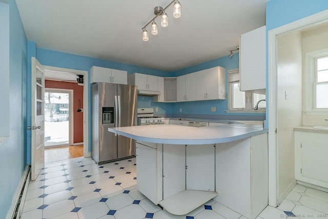 kitchen with sink, stainless steel fridge, a baseboard heating unit, white range with gas cooktop, and kitchen peninsula