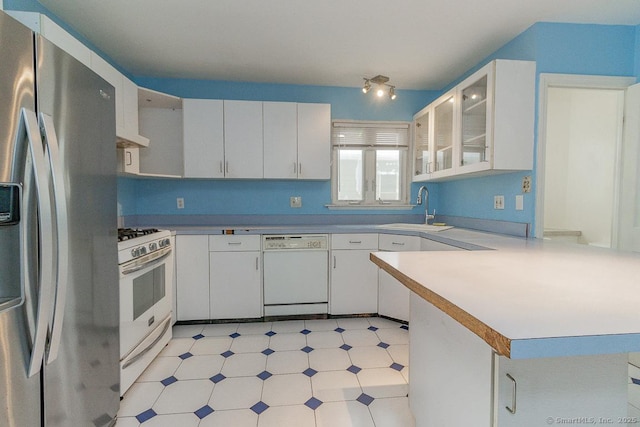 kitchen with white appliances, sink, and white cabinets