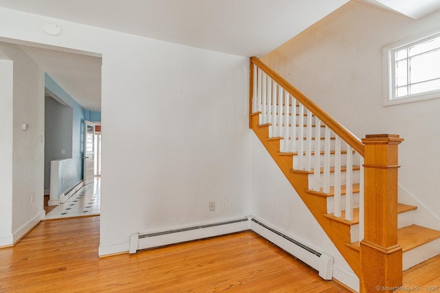 stairs with hardwood / wood-style flooring and baseboard heating