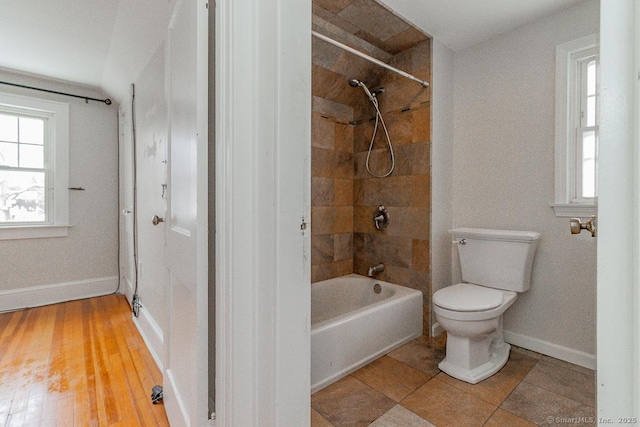 bathroom featuring tiled shower / bath and toilet