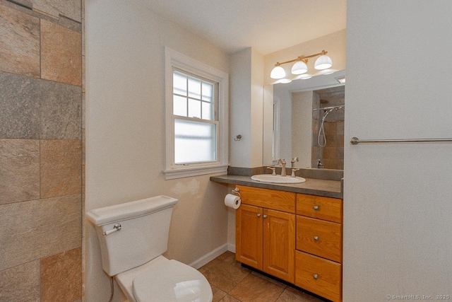 bathroom featuring tiled shower, vanity, toilet, and tile patterned flooring