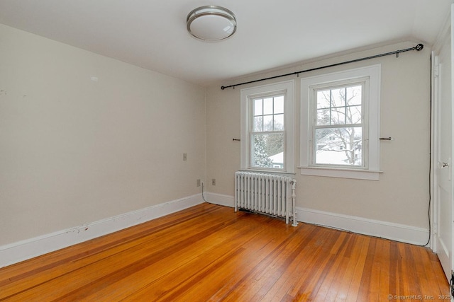 spare room with wood-type flooring and radiator heating unit