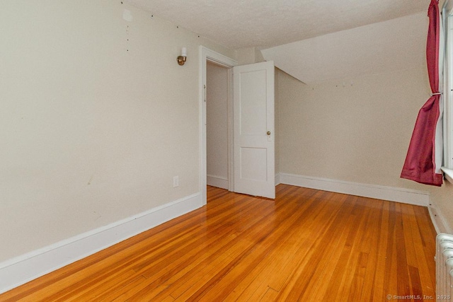 spare room featuring radiator and hardwood / wood-style flooring