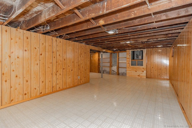 basement featuring wood walls