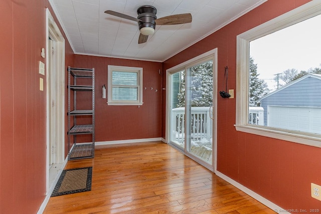 entryway featuring ceiling fan, ornamental molding, and light wood-type flooring