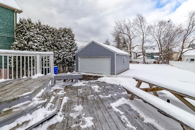 snow covered deck with an outbuilding and a garage