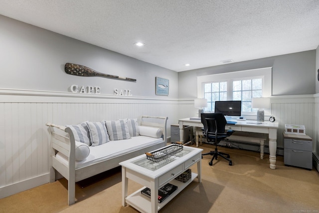 carpeted home office featuring a textured ceiling