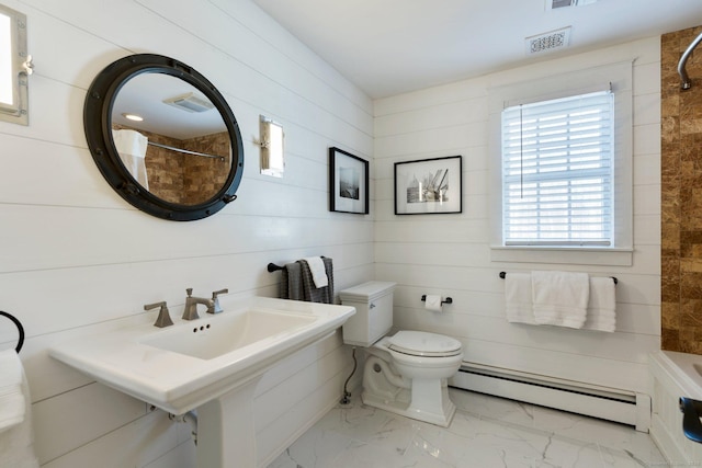 bathroom featuring wood walls, toilet, and a baseboard heating unit