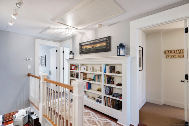 hallway with carpet flooring and a textured ceiling