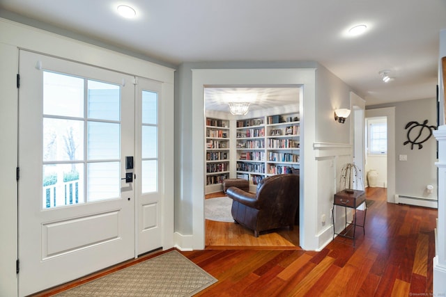 entrance foyer with a chandelier, a baseboard radiator, and dark hardwood / wood-style floors