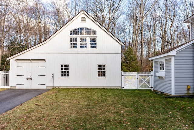 view of side of home featuring a lawn and an outbuilding