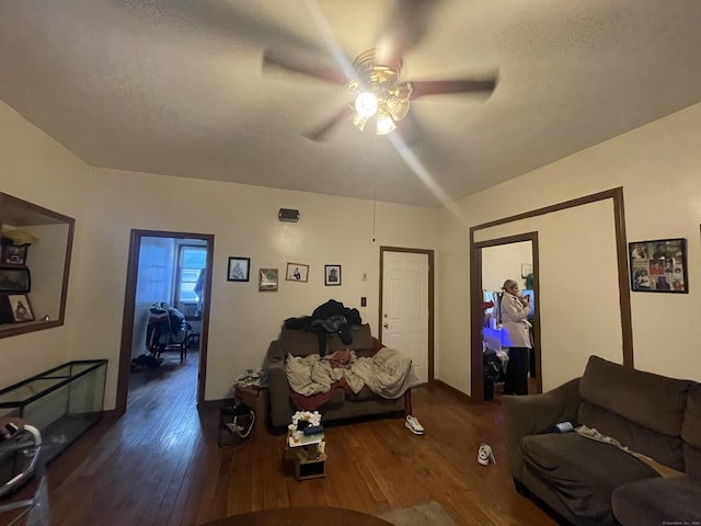 living room with ceiling fan, dark hardwood / wood-style flooring, and a textured ceiling