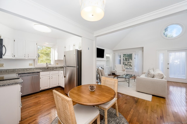 dining space with sink, light hardwood / wood-style floors, plenty of natural light, and crown molding