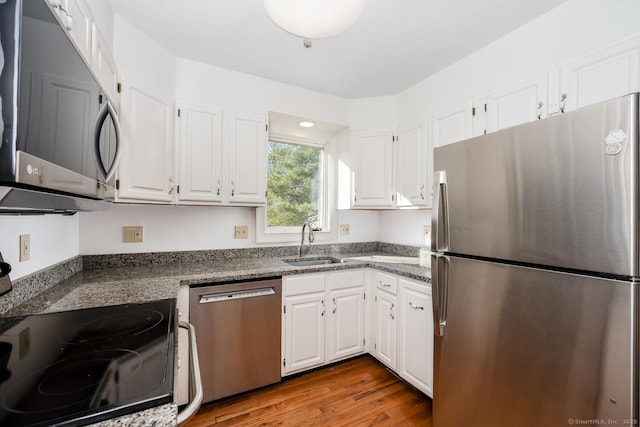 kitchen with sink, white cabinetry, light hardwood / wood-style flooring, and appliances with stainless steel finishes