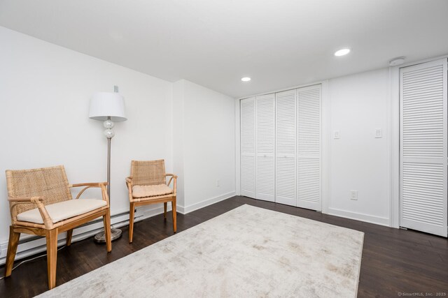 sitting room with a baseboard radiator and dark wood-type flooring