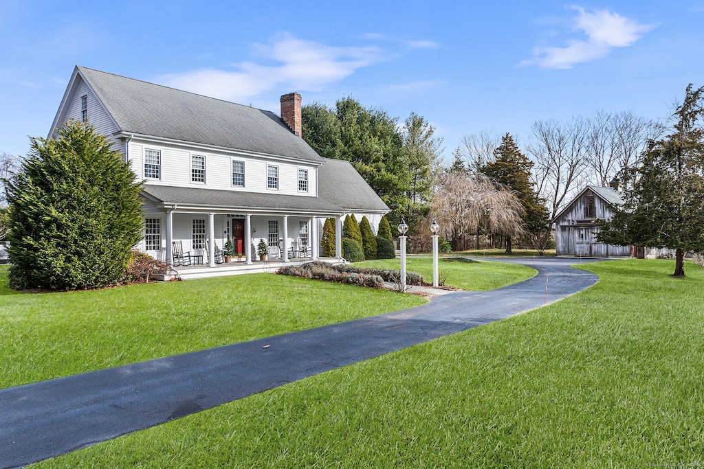 view of front of house featuring covered porch and a front lawn