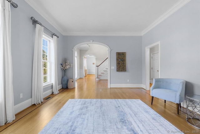 living area with ornamental molding and light hardwood / wood-style floors