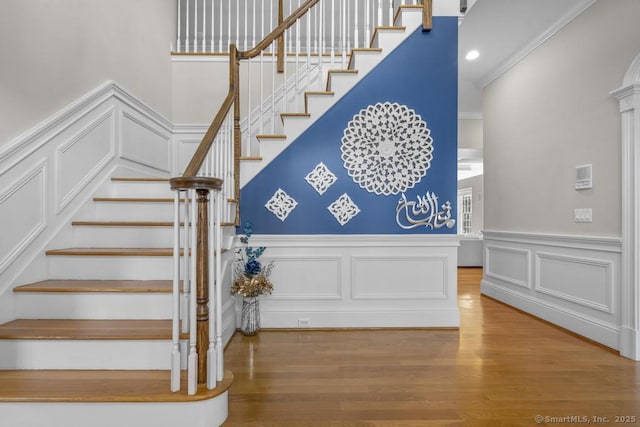 stairs featuring hardwood / wood-style flooring and crown molding