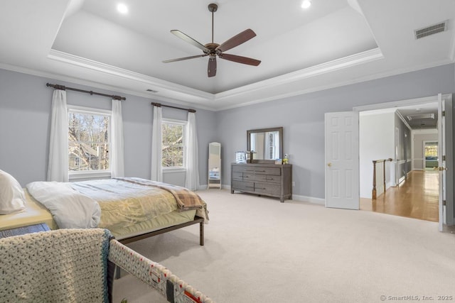 bedroom featuring a raised ceiling, ornamental molding, carpet floors, and ceiling fan