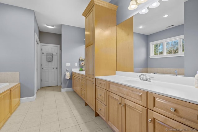 bathroom featuring tile patterned flooring, vanity, and a bathtub