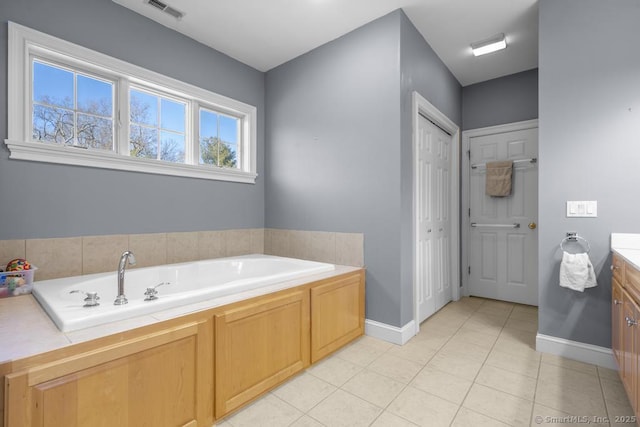 bathroom featuring vanity, tile patterned flooring, and a tub