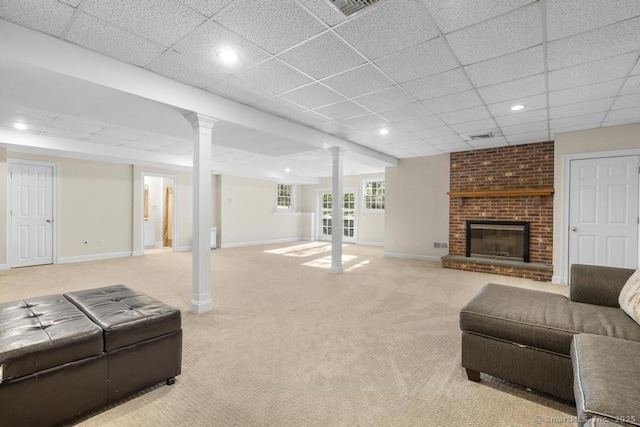 carpeted living room featuring a paneled ceiling, a fireplace, and ornate columns