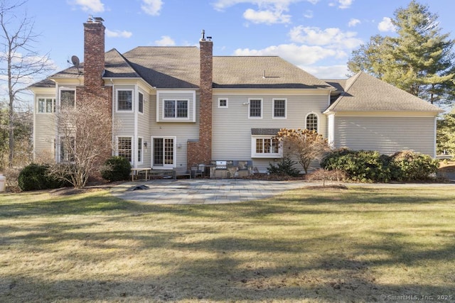 rear view of property featuring a lawn and a patio area