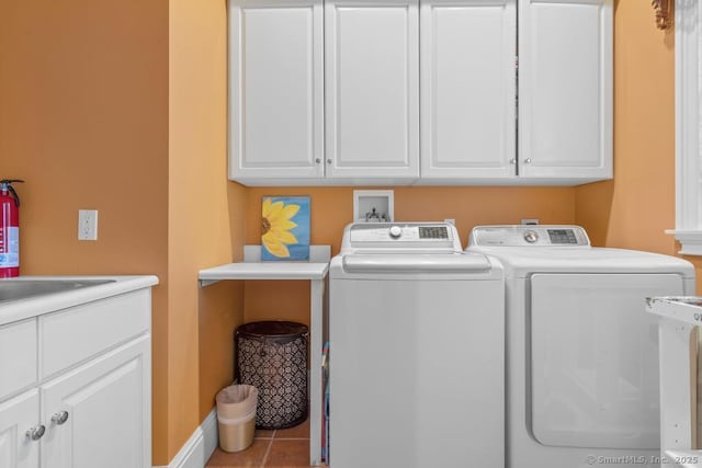 laundry area featuring cabinets, light tile patterned floors, and independent washer and dryer