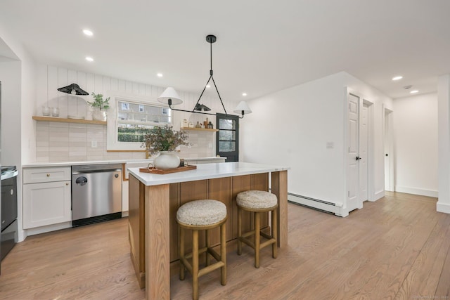 kitchen featuring baseboard heating, tasteful backsplash, stainless steel dishwasher, light hardwood / wood-style floors, and a kitchen island