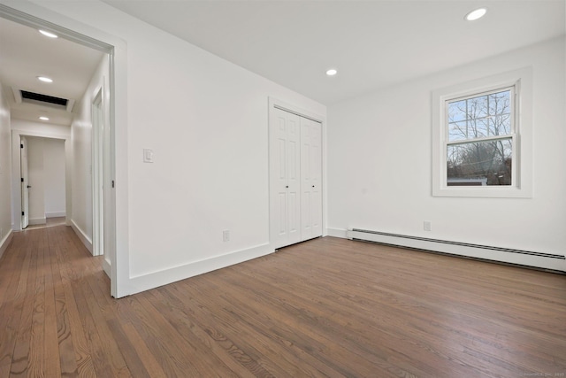 empty room featuring hardwood / wood-style floors and baseboard heating