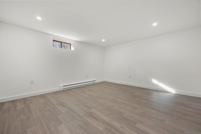 basement featuring hardwood / wood-style flooring and a baseboard radiator