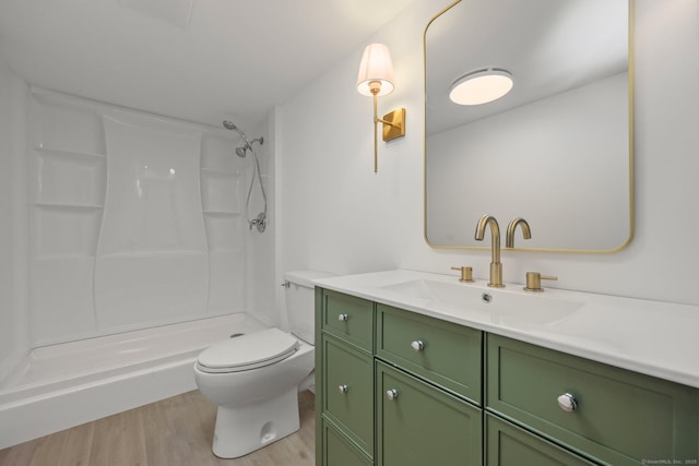 bathroom with walk in shower, hardwood / wood-style flooring, vanity, and toilet