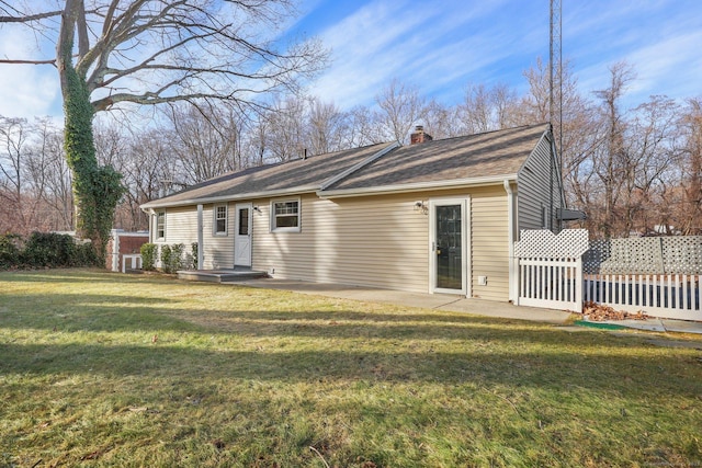 rear view of property with a lawn