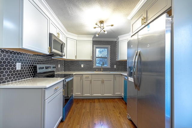 kitchen featuring backsplash, dark hardwood / wood-style flooring, white cabinets, and appliances with stainless steel finishes