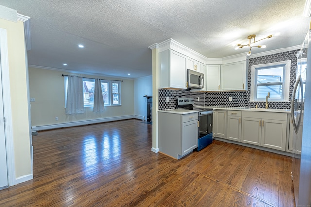 kitchen featuring white cabinets, ornamental molding, a baseboard heating unit, and appliances with stainless steel finishes