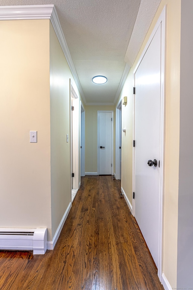 hall with a textured ceiling, dark hardwood / wood-style floors, crown molding, and a baseboard heating unit