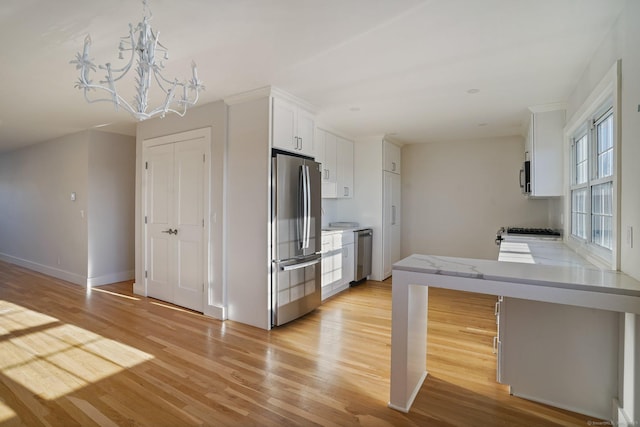 kitchen with light hardwood / wood-style flooring, a chandelier, hanging light fixtures, stainless steel appliances, and white cabinetry