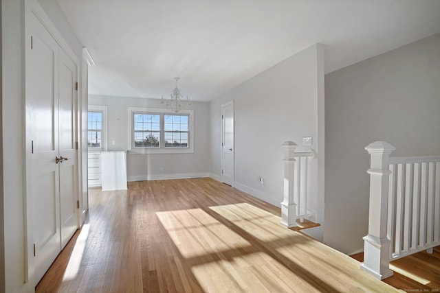 spare room featuring hardwood / wood-style floors and a chandelier