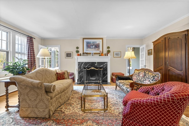 living room with a high end fireplace, light wood-type flooring, and ornamental molding