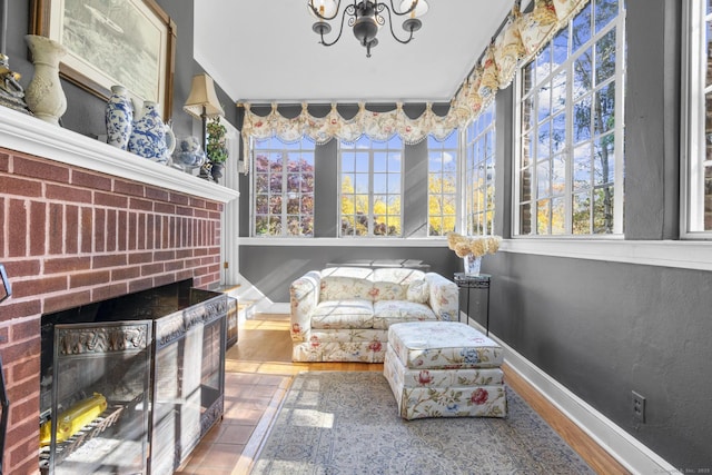 sunroom / solarium featuring a fireplace and a chandelier