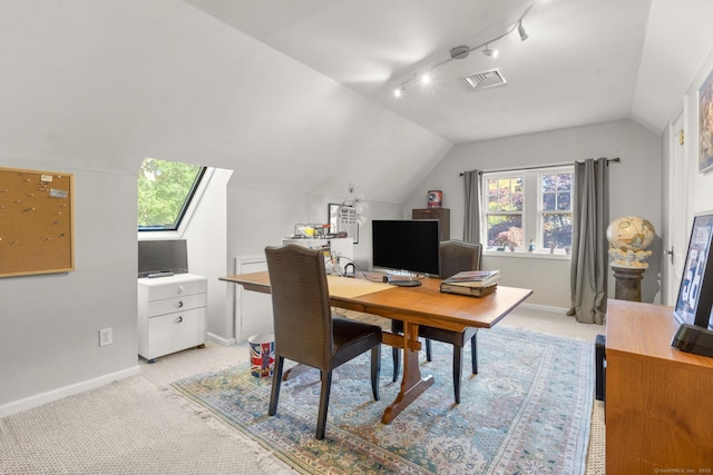 carpeted home office with a healthy amount of sunlight, track lighting, and lofted ceiling