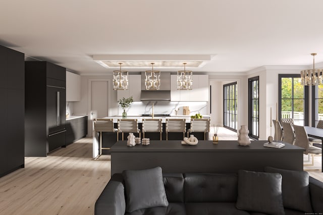 living room with light wood finished floors, a notable chandelier, and a raised ceiling