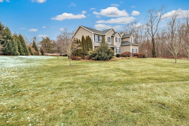 view of side of home with a yard